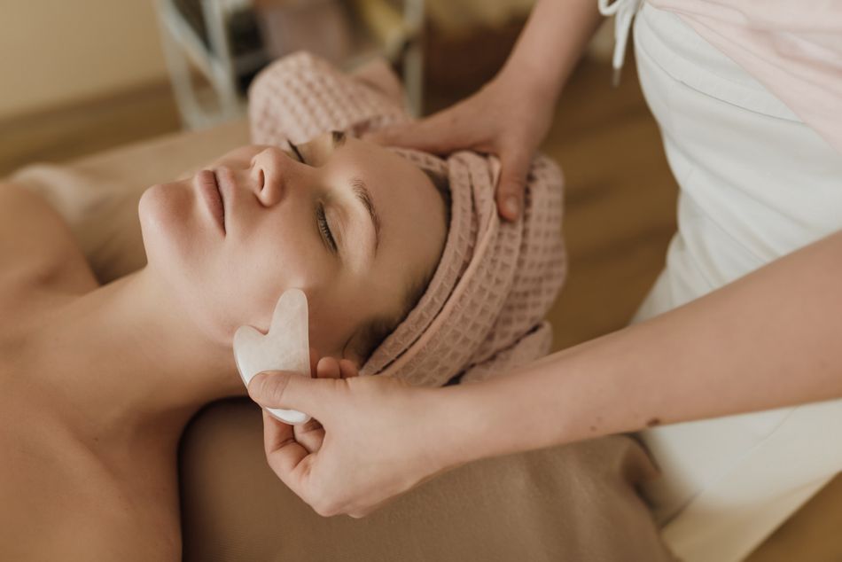 Gua Sha scraping or facial tool demonstrated on skin